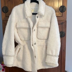 White faux fur Maeve at Anthropologie cozy coat with leather-look trim.